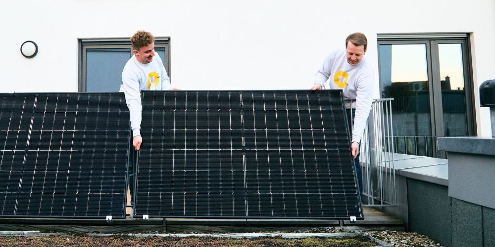 Zwei Menschen auf Balkon mit Solarmodul